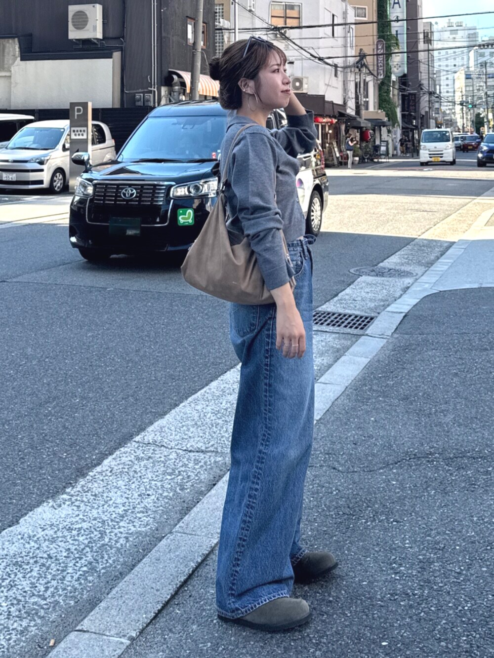 ベージュ系のスリッポン、グレー系のカーディガン/ボレロ、ブルー系のデニムパンツを着用したレディースの夏コーディネートの2枚目の写真