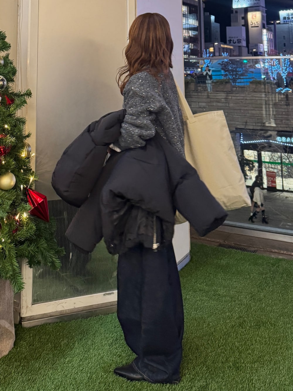 グレー系のカーディガン/ボレロ、ブラック系のダウンジャケット/コート、ホワイト系のトートバッグを着用したレディースの冬コーディネートの5枚目の写真