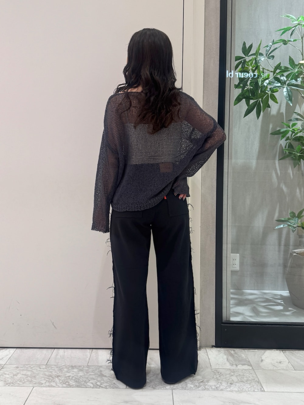 ブラック系のデニムパンツ、グレー系のニット/セーター、ブラック系のサンダルを着用したレディースの秋コーディネートの3枚目の写真