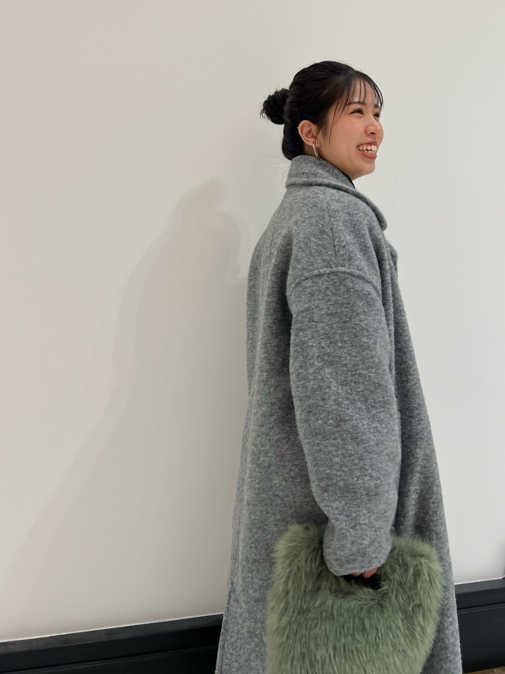 ブラウン系のブーツ、ブラック系のワンピース、グレー系のチェスターコートを着用したレディースの冬コーディネートの3枚目の写真