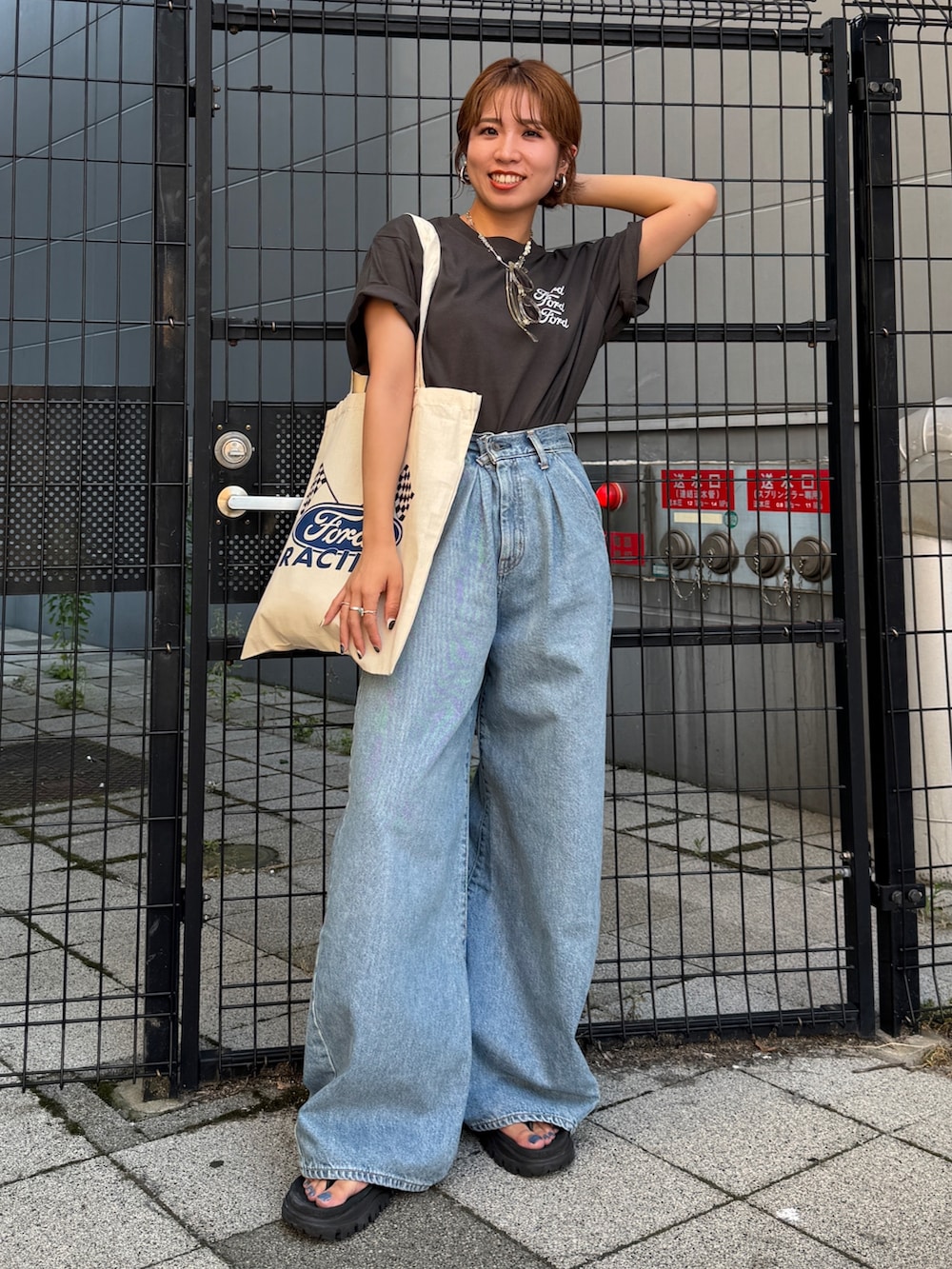 ブルー系のデニムパンツ、グレー系のTシャツ/カットソー、ホワイト系のトートバッグを着用したレディースの夏コーディネートの2枚目の写真