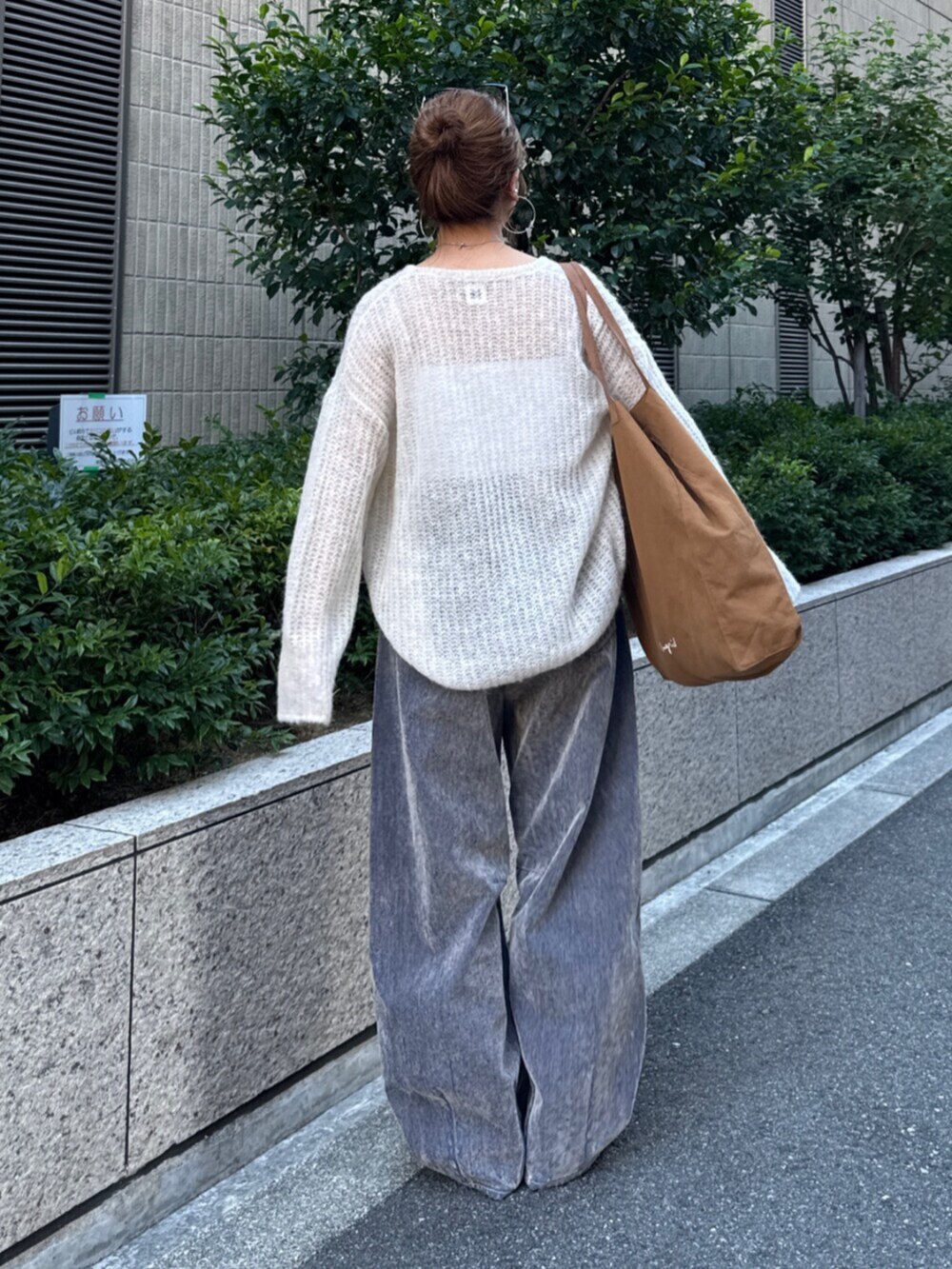 ベージュ系のデニムパンツ、ホワイト系のニット/セーター、ブラウン系のトートバッグを着用したレディースの夏コーディネートの4枚目の写真