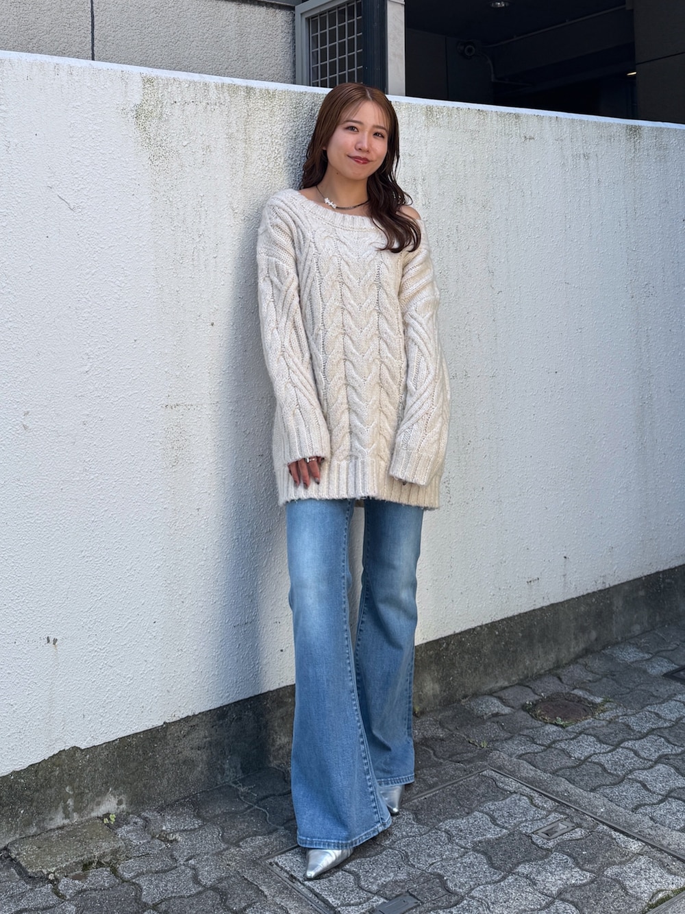 ホワイト系のニット/セーター、ブルー系のデニムパンツ、シルバー系のその他シューズを着用したレディースの夏コーディネートの6枚目の写真