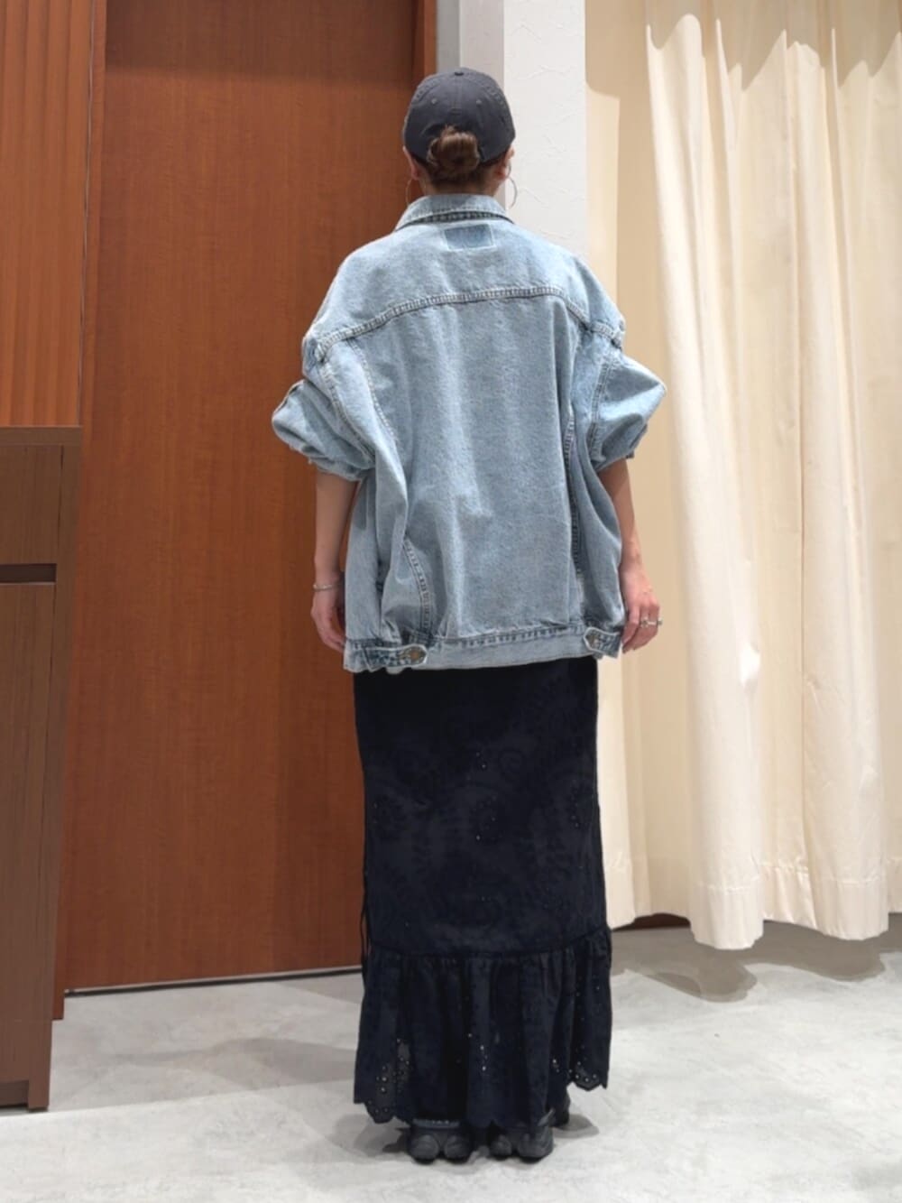 ブラック系のスカート、ブルー系のデニムジャケット、グレー系のスウェットを着用したレディースの春コーディネートの4枚目の写真