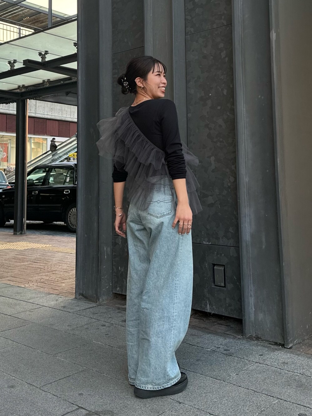 グレー系のベスト、ブラック系のTシャツ/カットソー、ブルー系のデニムパンツを着用したレディースの冬コーディネートの4枚目の写真