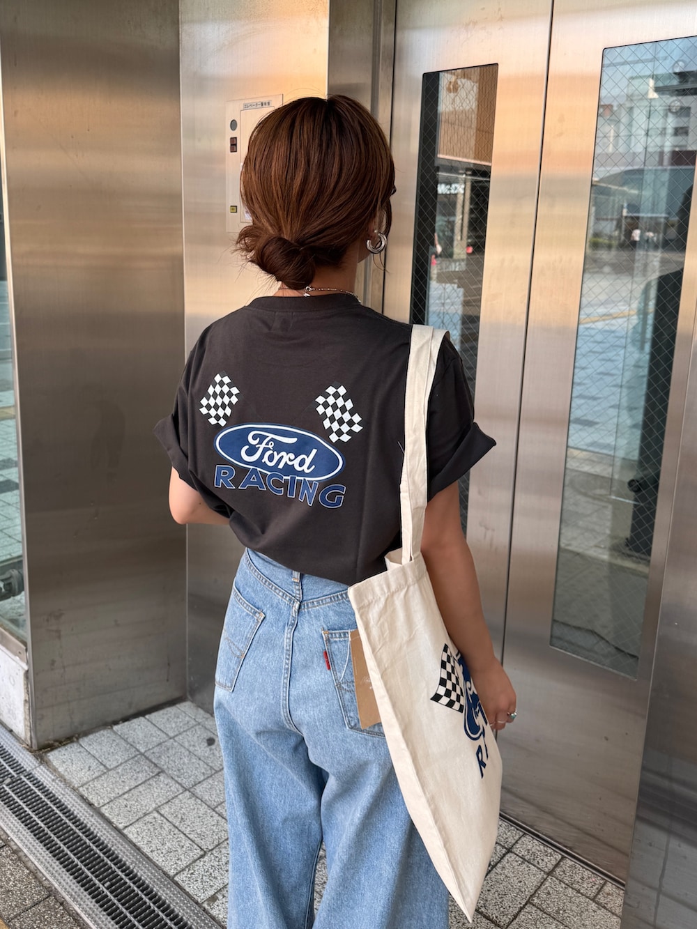 ブルー系のデニムパンツ、グレー系のTシャツ/カットソー、ホワイト系のトートバッグを着用したレディースの夏コーディネートの8枚目の写真