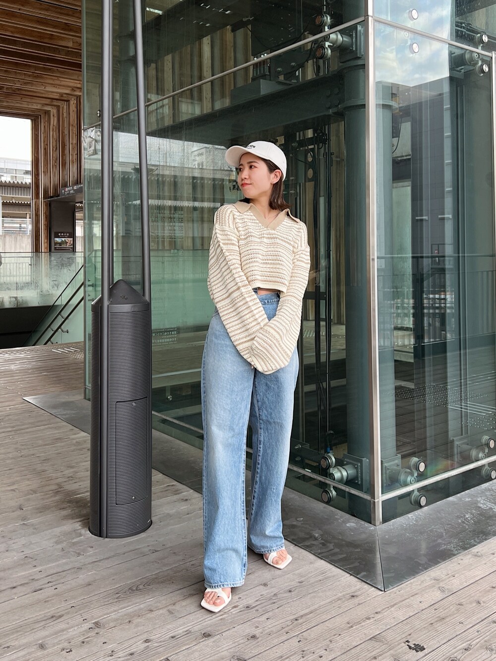 ベージュ系のニット/セーター、ブルー系のデニムパンツ、ホワイト系のサンダルを着用したレディースの春コーディネートの7枚目の写真