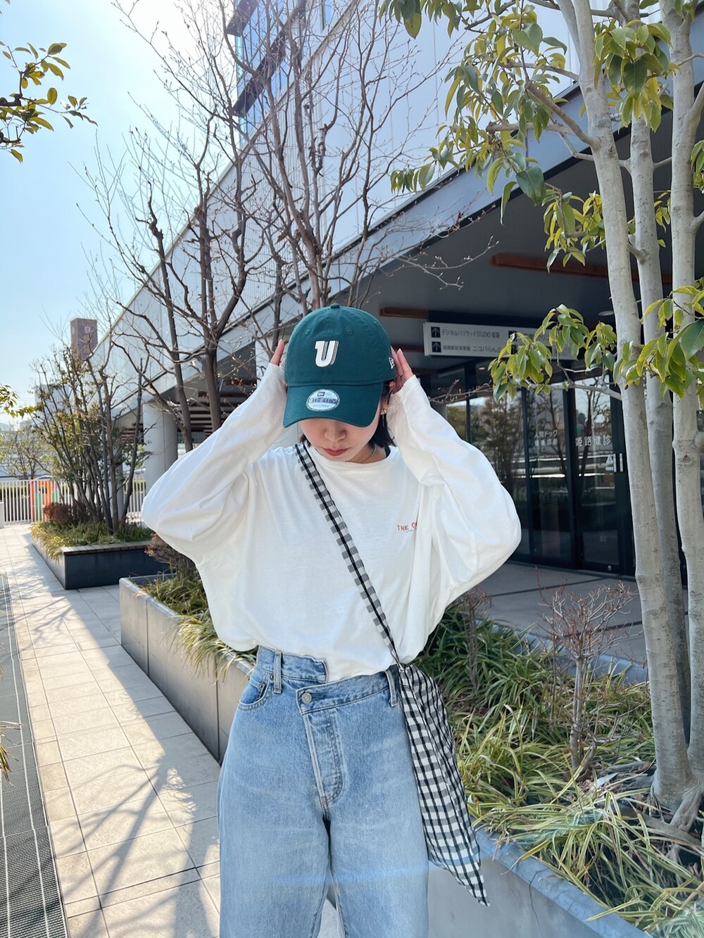 ブルー系のデニムパンツ、ホワイト系のTシャツ/カットソー、グレー系のショルダーバッグを着用したレディースの冬コーディネートの7枚目の写真