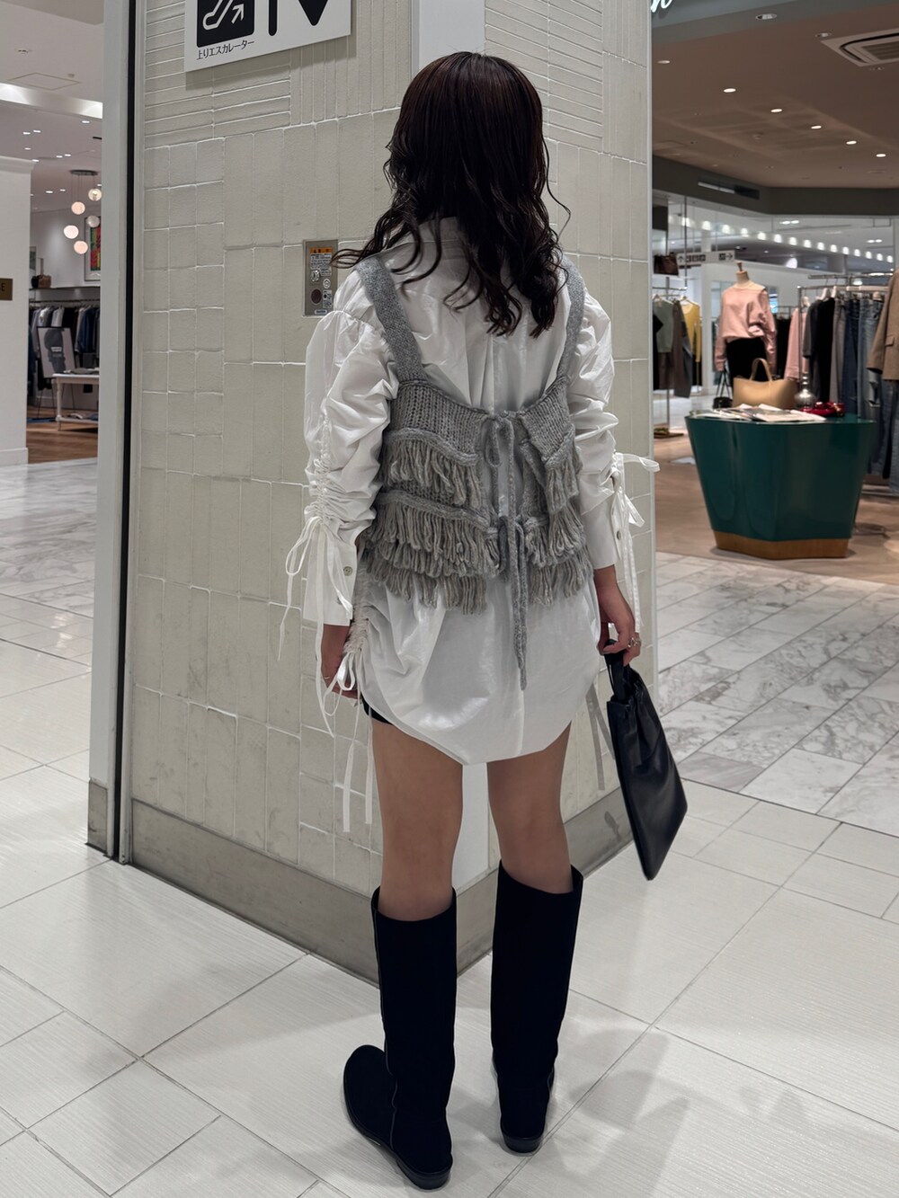 ホワイト系のシャツ/ブラウス、ブルー系のニット/セーター、ブラック系のショルダーバッグを着用したレディースの秋コーディネートの5枚目の写真