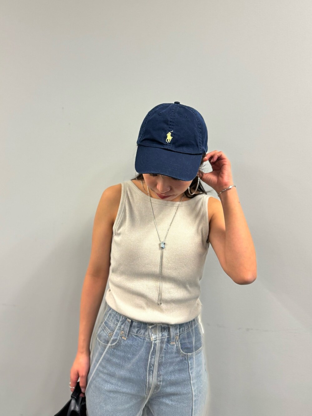 ブルー系のデニムパンツ、ベージュ系のその他パンツ、ホワイト系のタンクトップを着用したレディースの春コーディネートの7枚目の写真