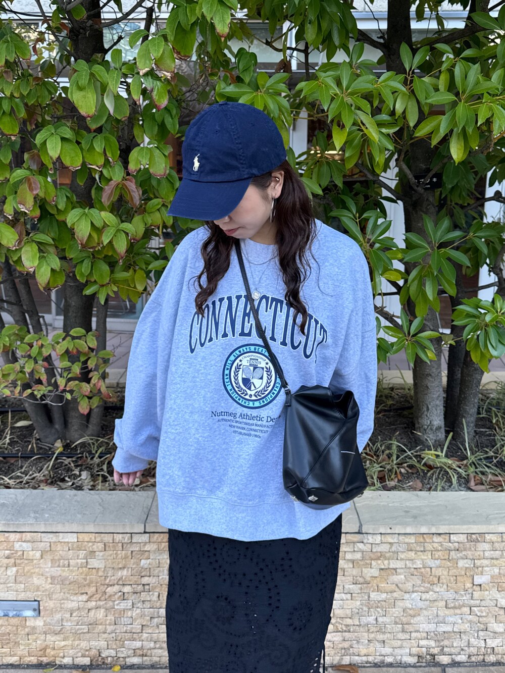 ブラック系のスカート、グレー系のスウェット、ブラック系のスニーカーを着用したレディースの冬コーディネートの7枚目の写真