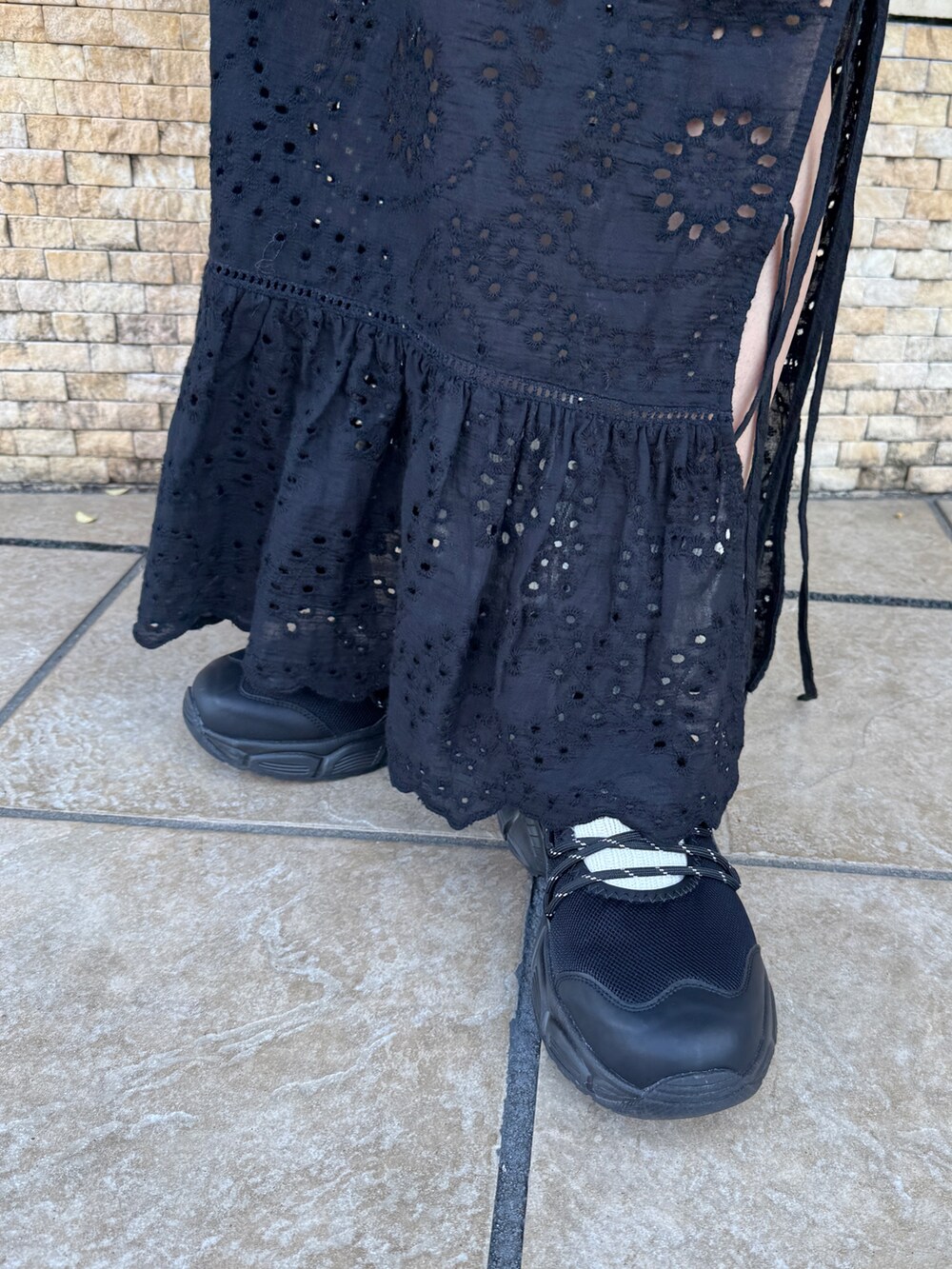 ブラック系のスカート、グレー系のスウェット、ブラック系のスニーカーを着用したレディースの冬コーディネートの10枚目の写真