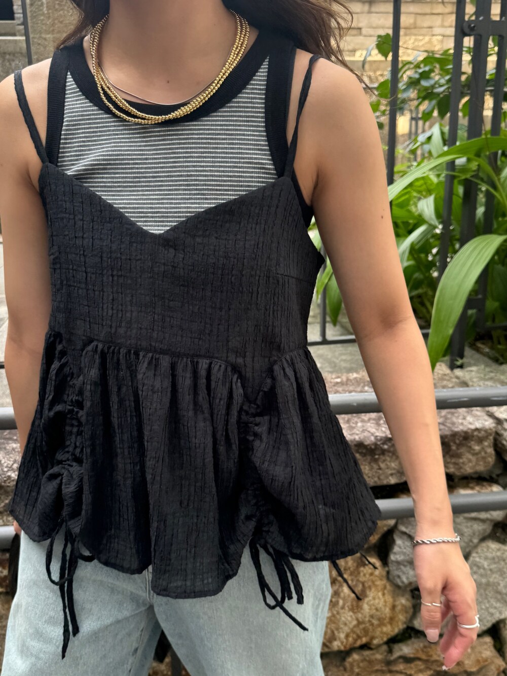 グレー系のタンクトップ、ブラック系のシャツ/ブラウス、ブルー系のデニムパンツを着用したレディースの夏コーディネートの9枚目の写真