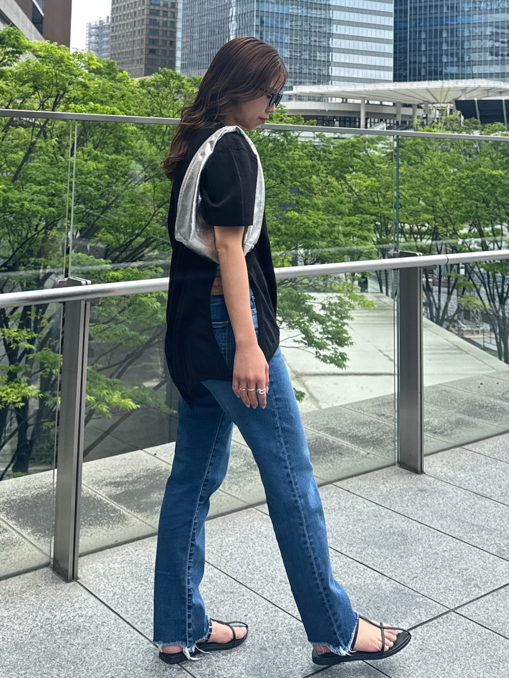 ブラック系のTシャツ/カットソー、ブルー系のデニムパンツを着用したレディースの春コーディネートの3枚目の写真