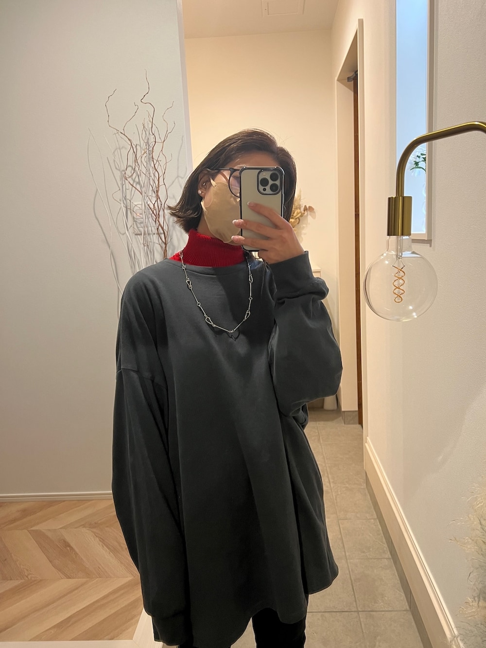 グレー系のTシャツ/カットソー、レッド系のニット/セーター、ブラック系のデニムパンツを着用したレディースの冬コーディネートの2枚目の写真