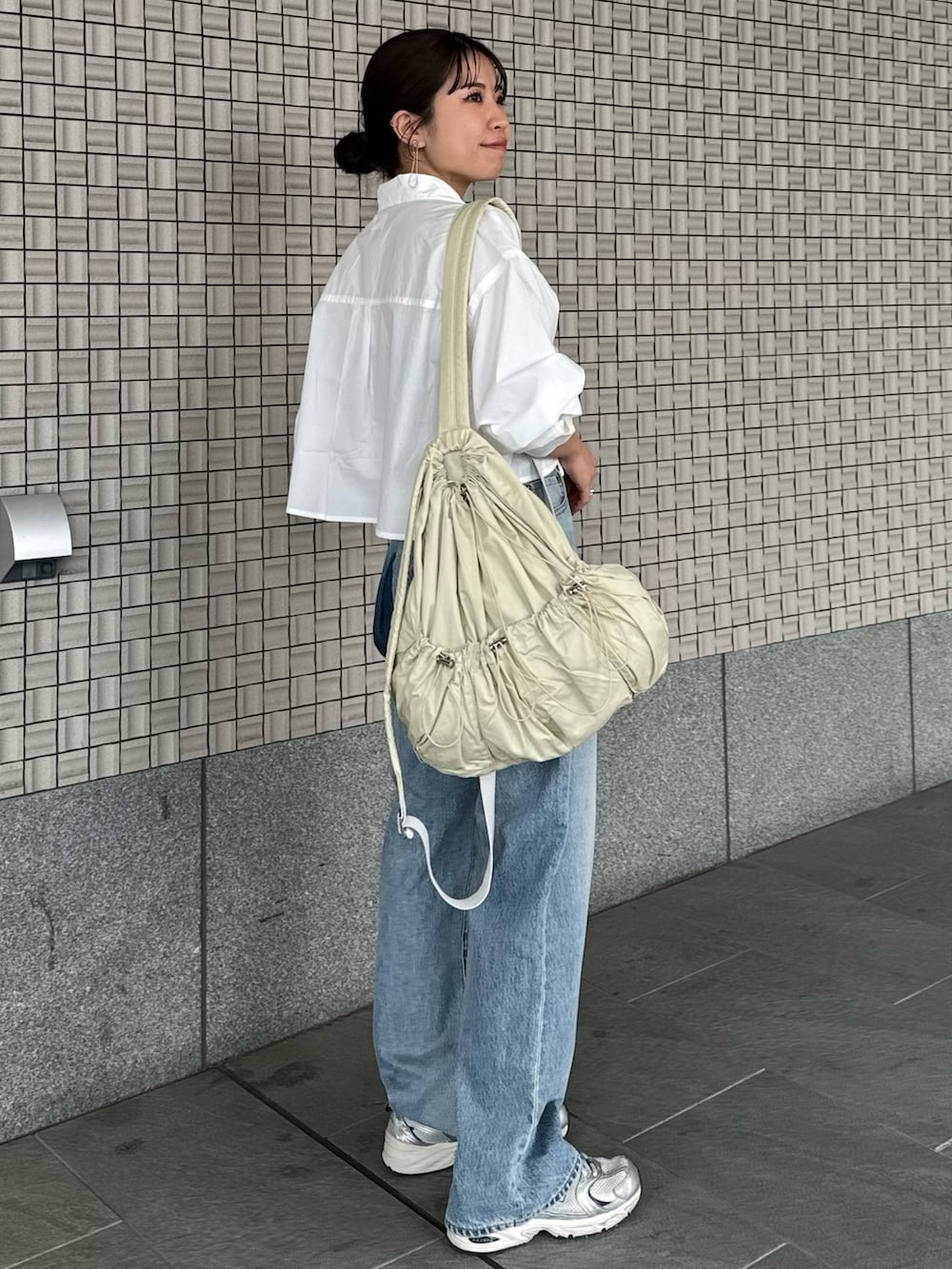 ブルー系のデニムパンツ、ホワイト系のシャツ/ブラウス、ブラック系のキャミソールを着用したレディースの春コーディネートの4枚目の写真