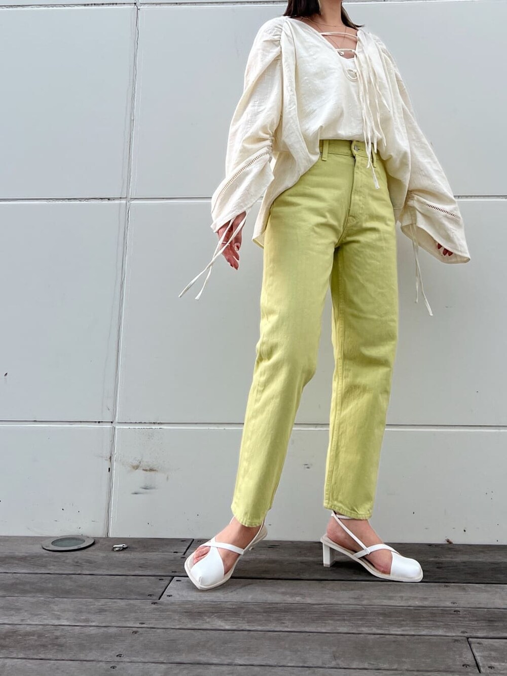 グリーン系のデニムパンツ、ホワイト系のシャツ/ブラウス、ホワイト系のサンダルを着用したレディースの春コーディネートの5枚目の写真