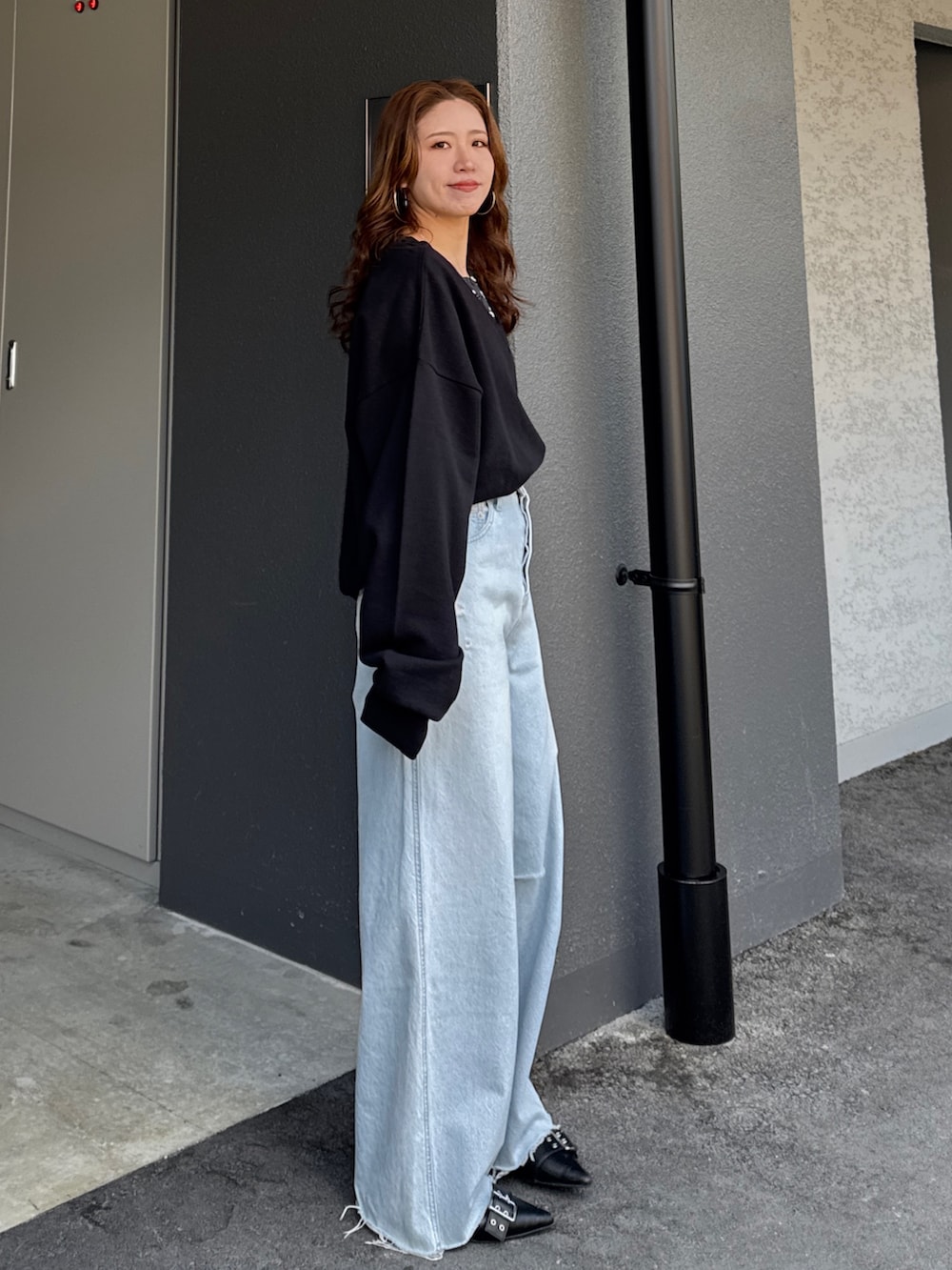 ブラック系のスウェット、グレー系のTシャツ/カットソー、ブルー系のデニムパンツを着用したレディースの春コーディネートの3枚目の写真