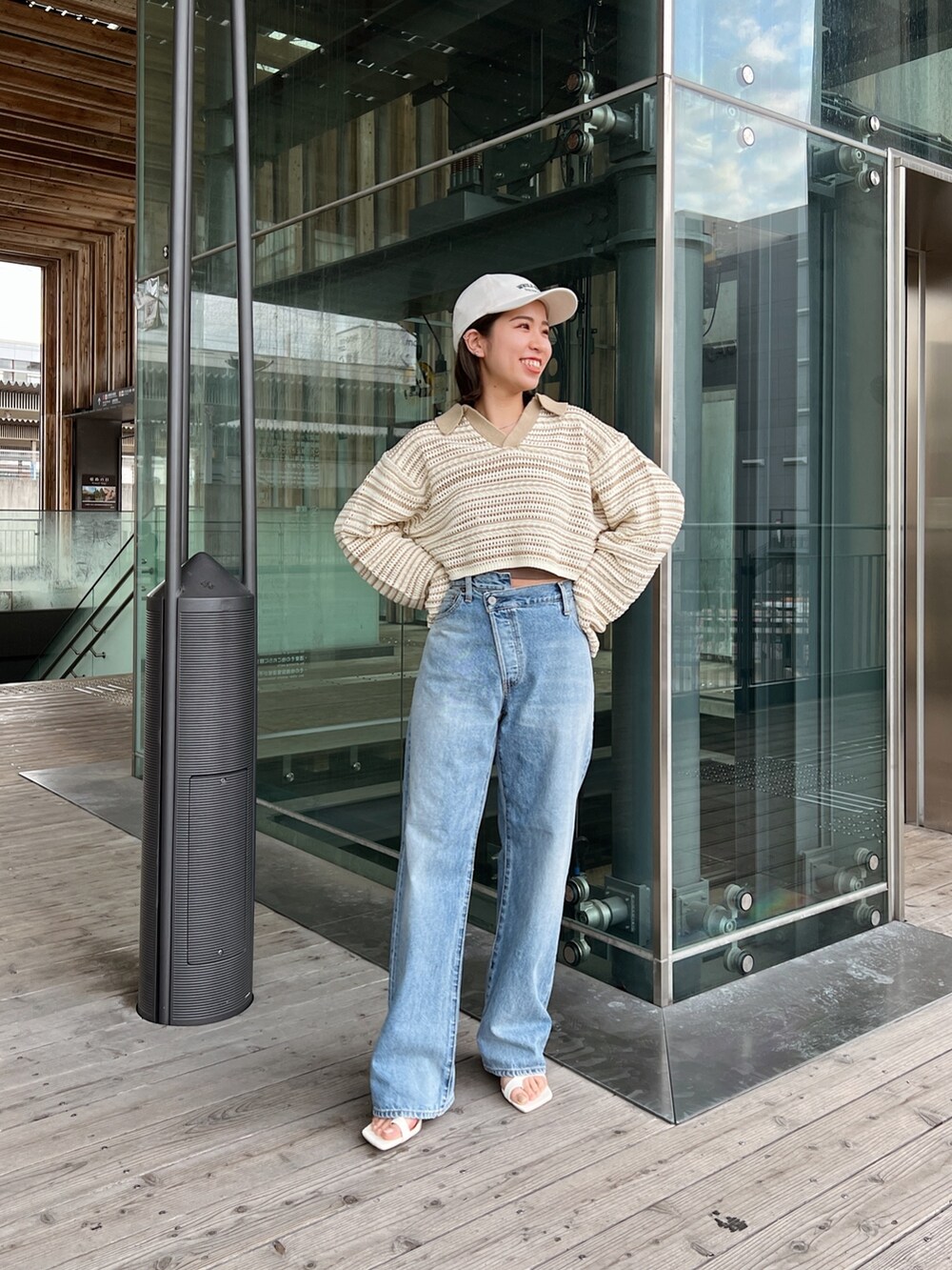 ベージュ系のニット/セーター、ブルー系のデニムパンツ、ホワイト系のサンダルを着用したレディースの春コーディネートの3枚目の写真