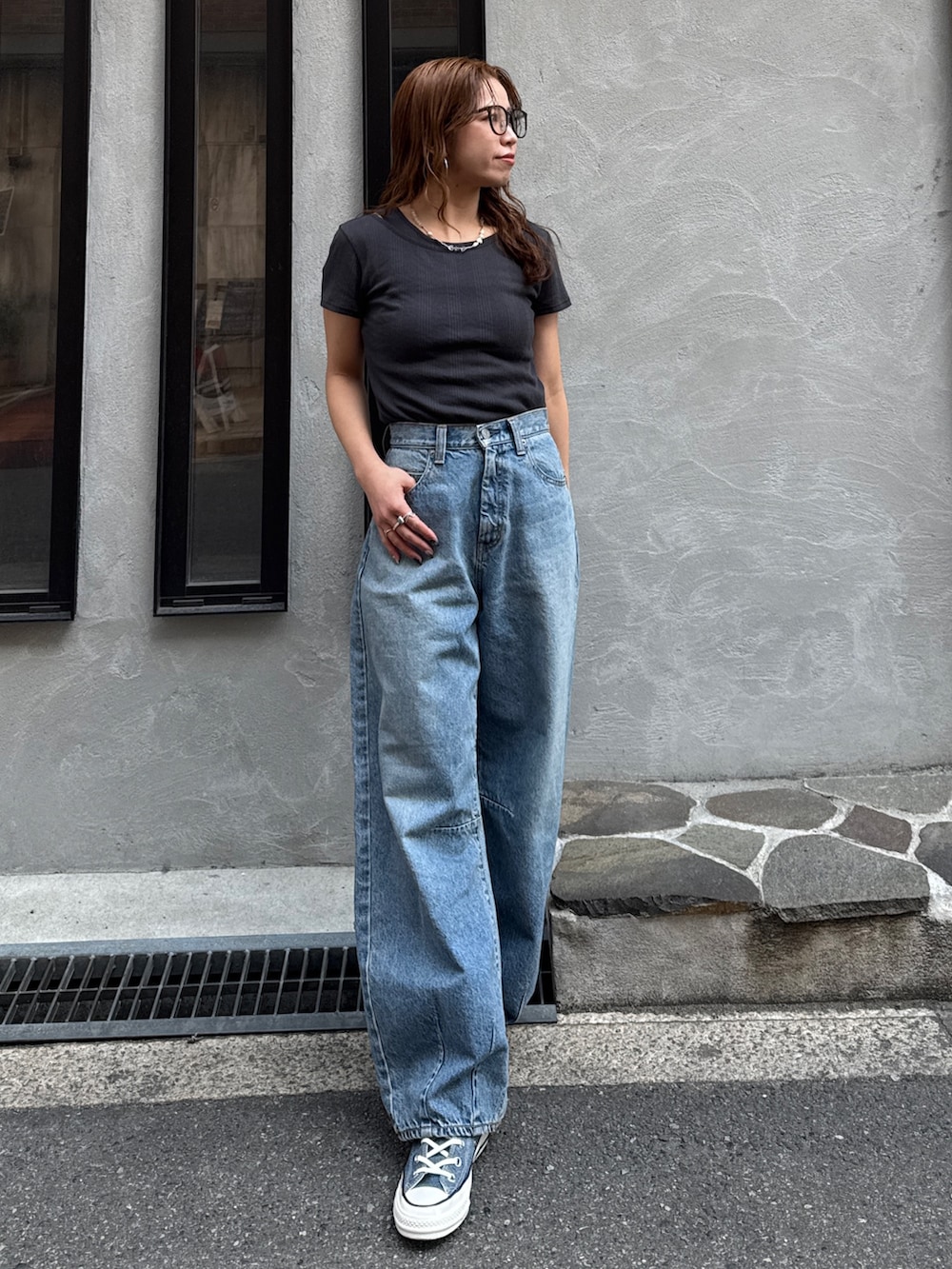 ブルー系のデニムパンツ、ブルー系のスニーカー、グレー系のTシャツ/カットソーを着用したレディースの春コーディネートの2枚目の写真