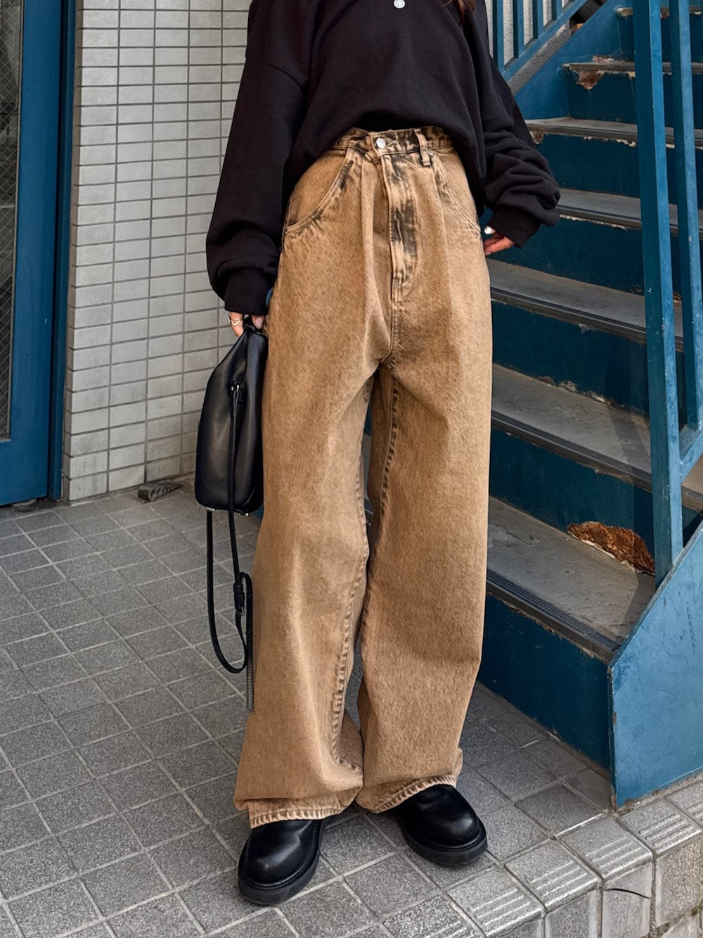 ブラウン系のデニムパンツ、ブラック系のスウェットを着用したレディースの冬コーディネートの3枚目の写真