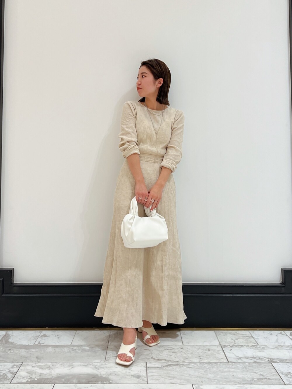 ホワイト系のベスト、ホワイト系のワンピース、ホワイト系のハンドバッグを着用したレディースの春コーディネートの3枚目の写真