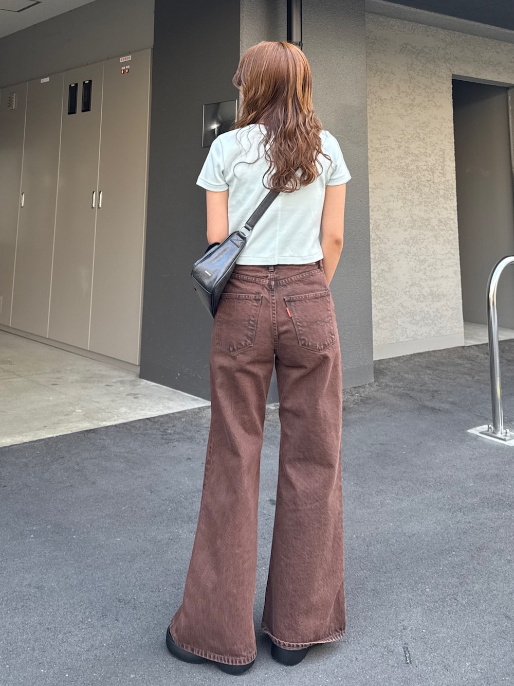 ブラウン系のデニムパンツ、ブルー系のTシャツ/カットソーを着用したレディースの春コーディネートの4枚目の写真