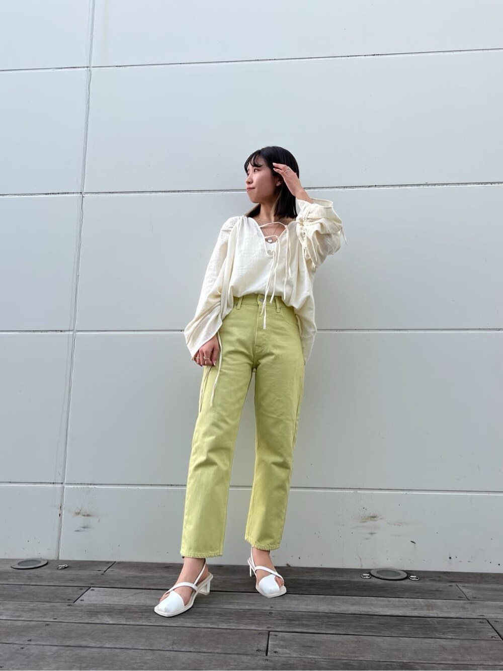 グリーン系のデニムパンツ、ホワイト系のシャツ/ブラウス、ホワイト系のサンダルを着用したレディースの春コーディネートの2枚目の写真