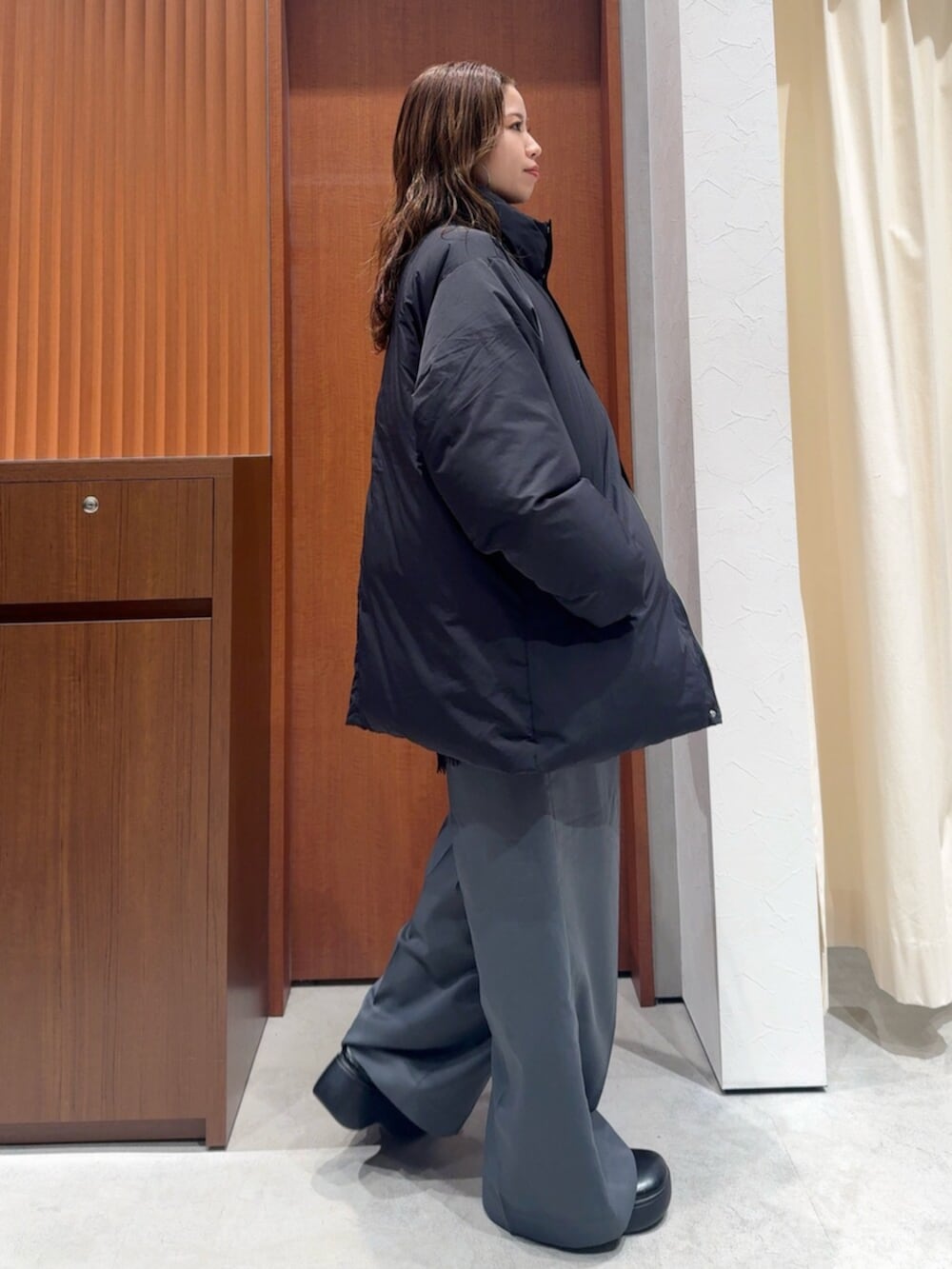 ブラック系のダウンジャケット/コート、グレー系のその他パンツ、ブラック系のキャミソールを着用したレディースの冬コーディネートの2枚目の写真