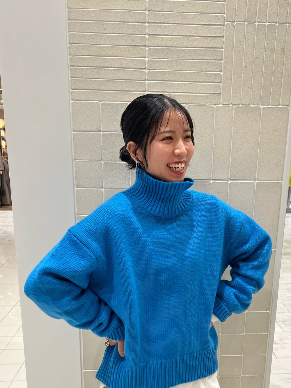 ブルー系のニット/セーター、ホワイト系のTシャツ/カットソー、ブラック系のブーツを着用したレディースの秋コーディネートの5枚目の写真