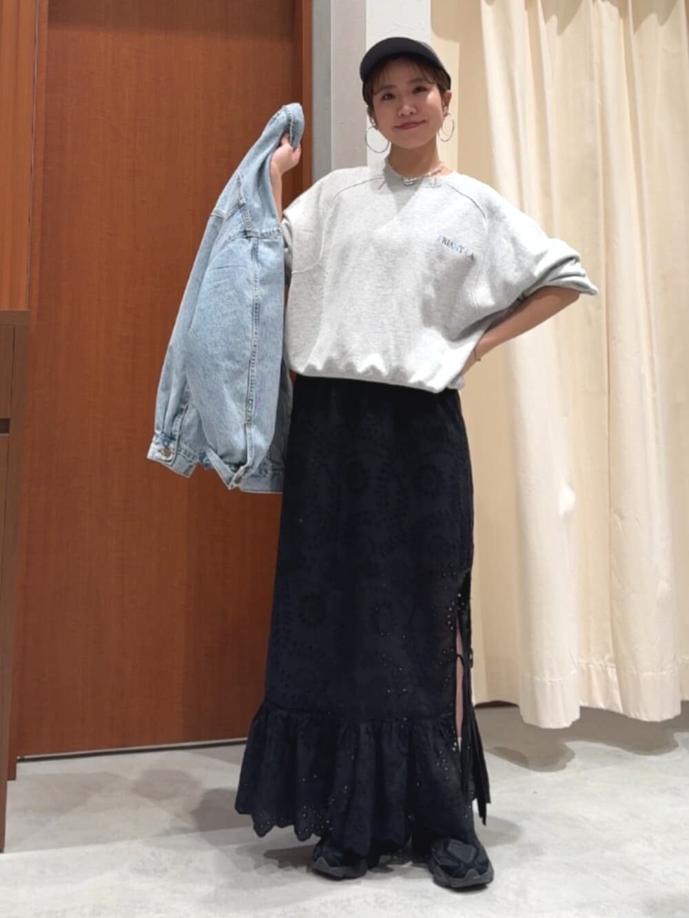 ブラック系のスカート、ブルー系のデニムジャケット、グレー系のスウェットを着用したレディースの春コーディネートの6枚目の写真