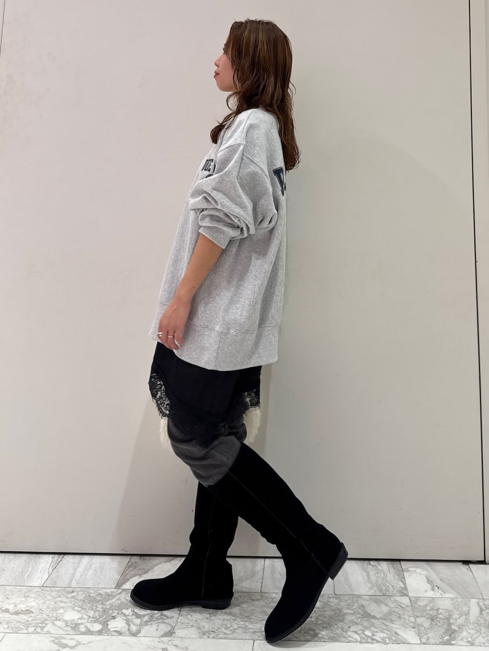 グレー系のスウェット、ブラック系のキャミソール、ブラック系のデニムパンツを着用したレディースの冬コーディネートの6枚目の写真