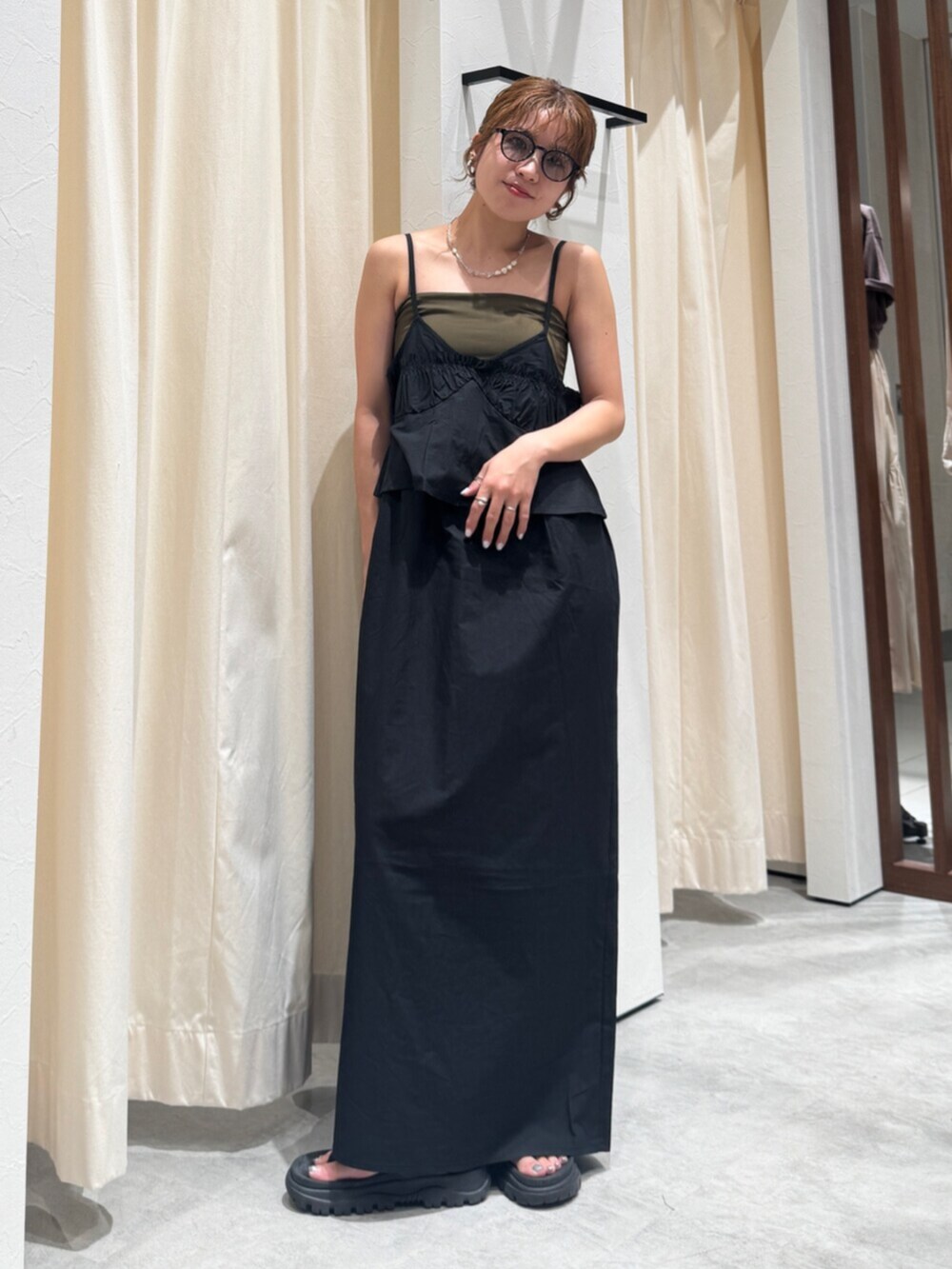 ブラック系のワンピース、グレー系のサングラスを着用したレディースの春コーディネートの4枚目の写真