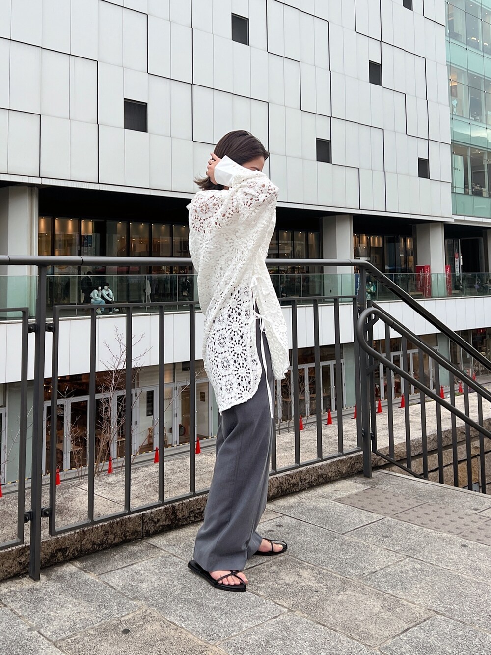 ホワイト系のシャツ/ブラウス、グレー系のその他パンツ、ブラック系のサンダルを着用したレディースの春コーディネートの2枚目の写真