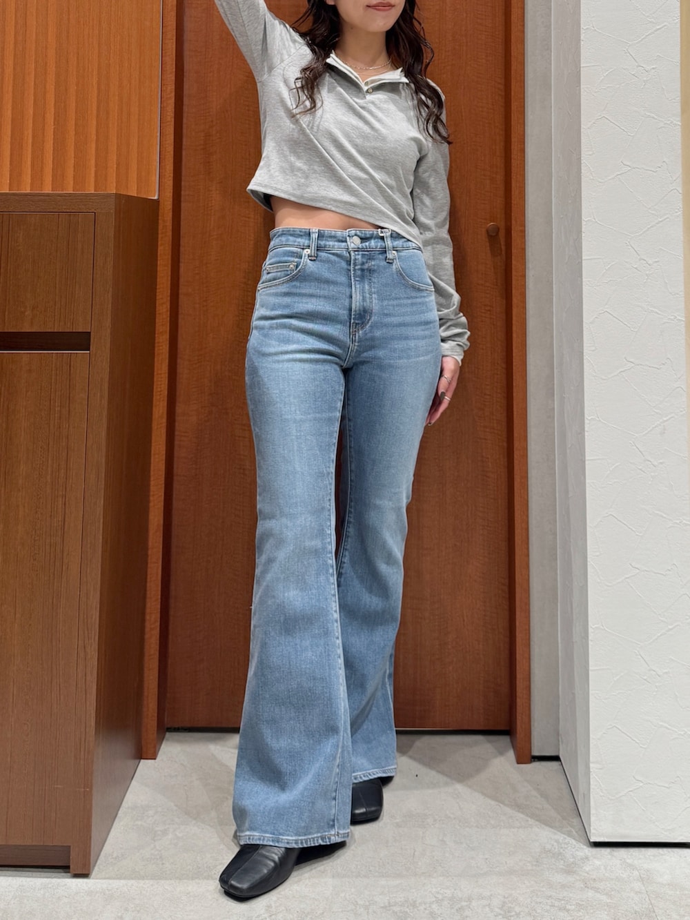 ブルー系のデニムパンツ、ブラック系のサンダル、グレー系のTシャツ/カットソーを着用したレディースの秋コーディネートの2枚目の写真