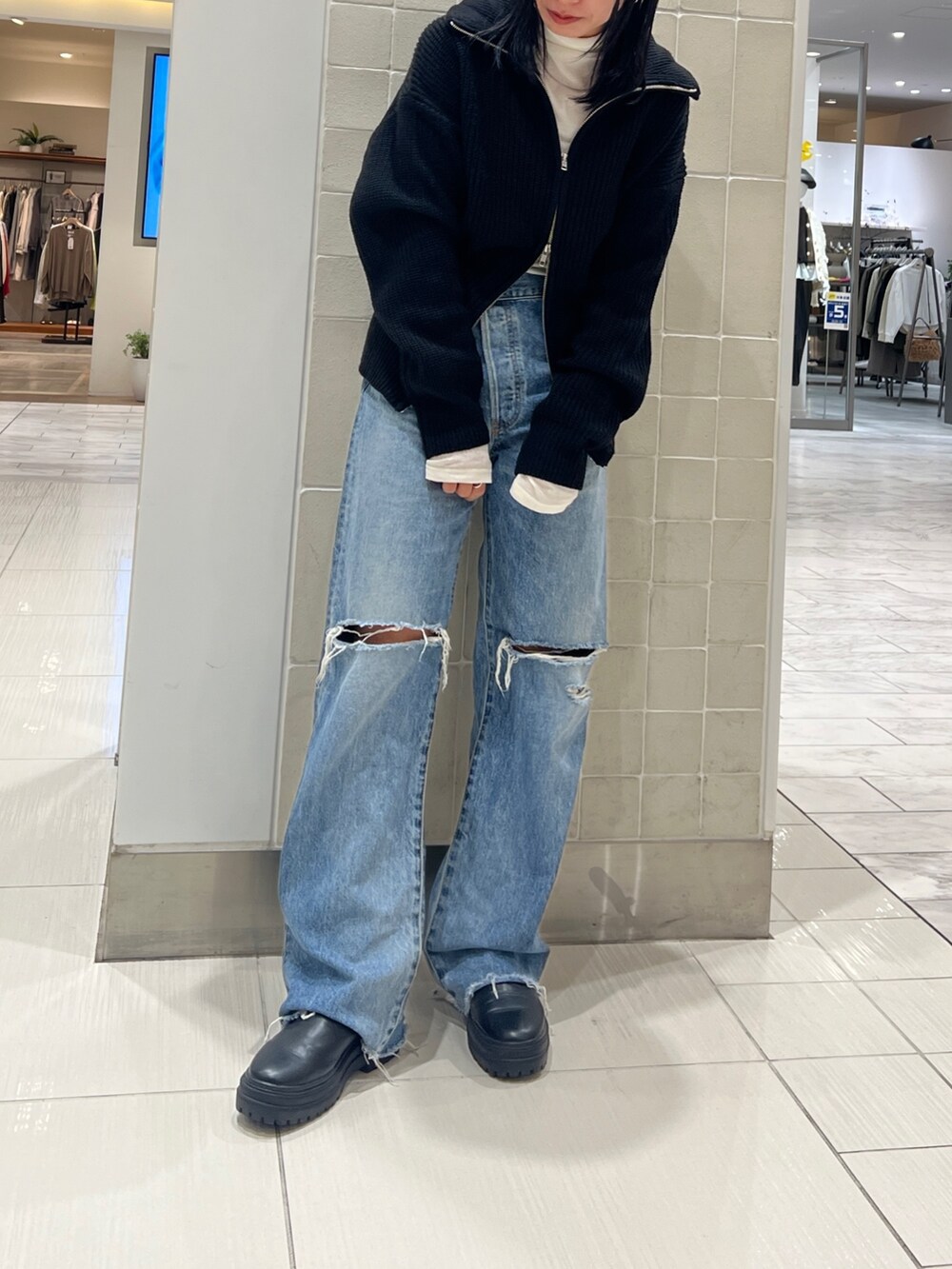 ブルー系のデニムパンツ、ブラック系のカーディガン/ボレロ、ホワイト系のTシャツ/カットソーを着用したレディースの秋コーディネートの2枚目の写真