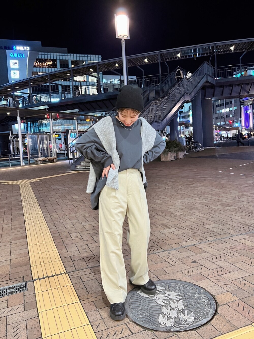 グレー系のTシャツ/カットソー、グレー系のニット/セーター、ベージュ系のスラックスを着用したレディースの冬コーディネートの4枚目の写真