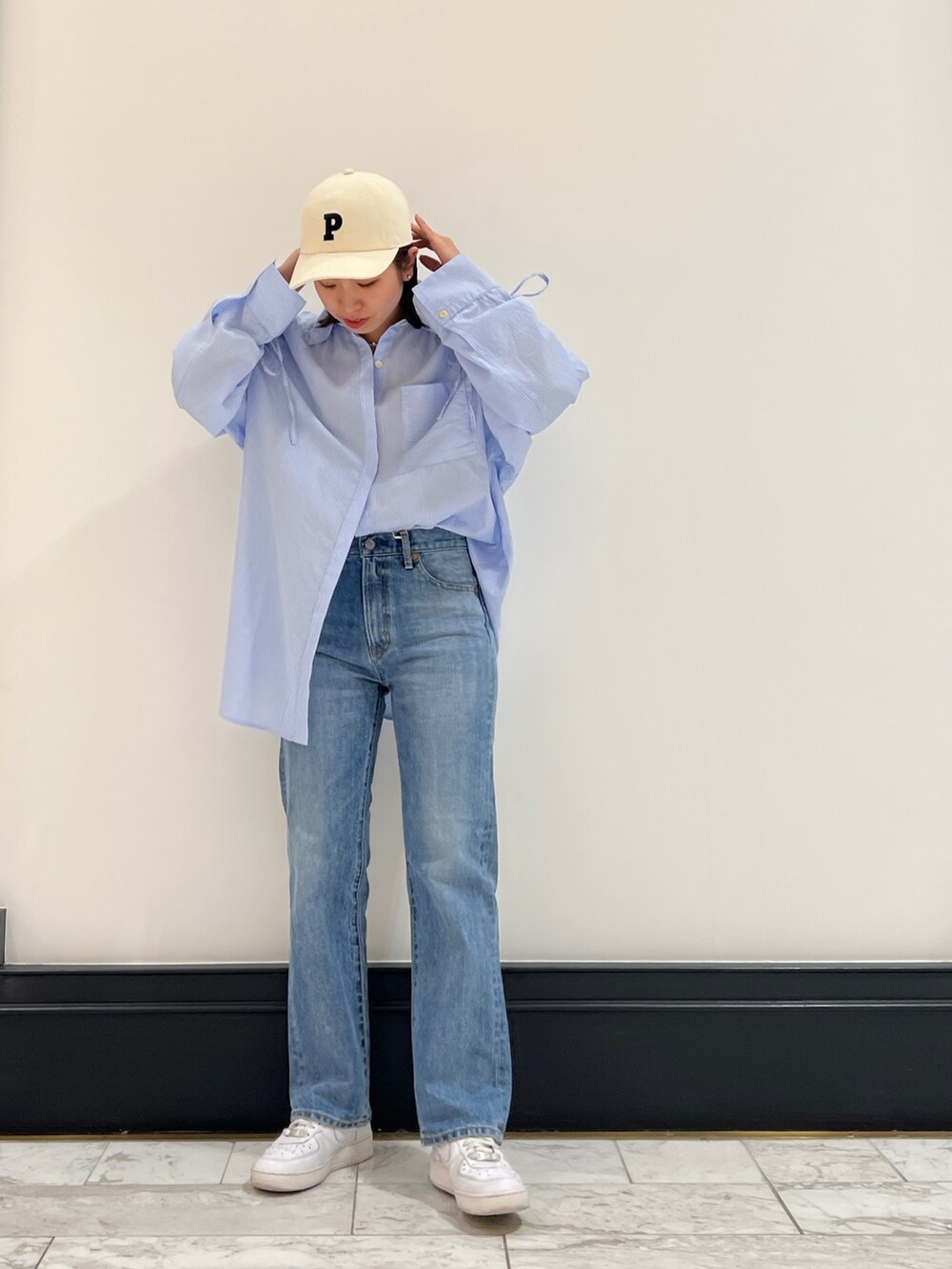 ブルー系のデニムパンツ、その他のシャツ/ブラウス、ホワイト系のキャップを着用したレディースの春コーディネートの3枚目の写真