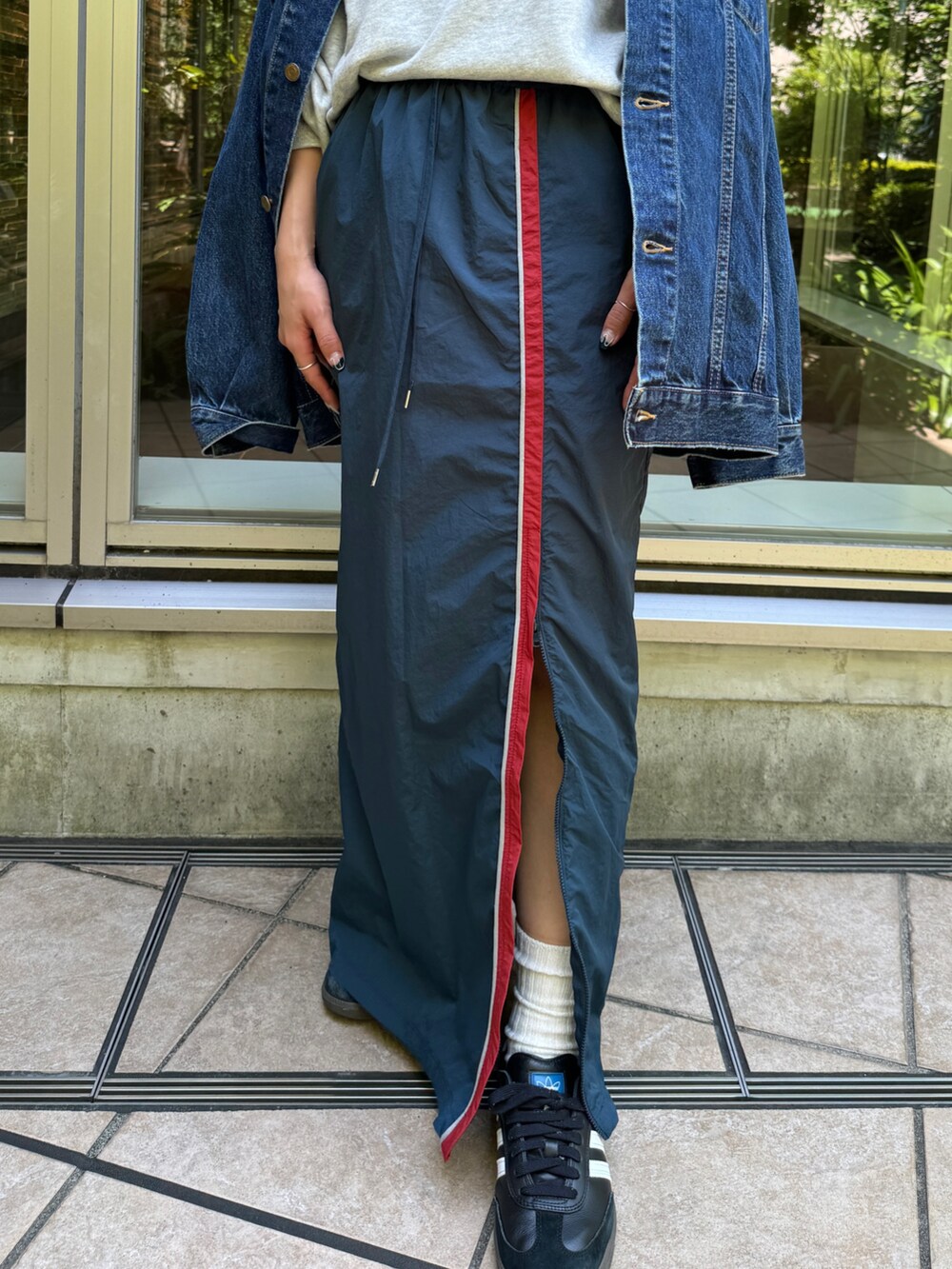 ブルー系のスカート、グレー系のスウェット、ブルー系のデニムジャケットを着用したレディースの夏コーディネートの9枚目の写真