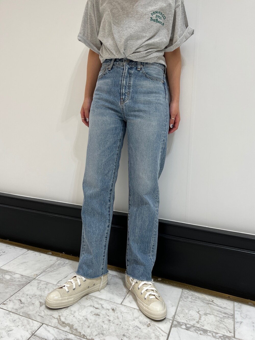 ブルー系のデニムパンツ、グレー系のTシャツ/カットソー、ホワイト系のスニーカーを着用したレディースの春コーディネートの9枚目の写真