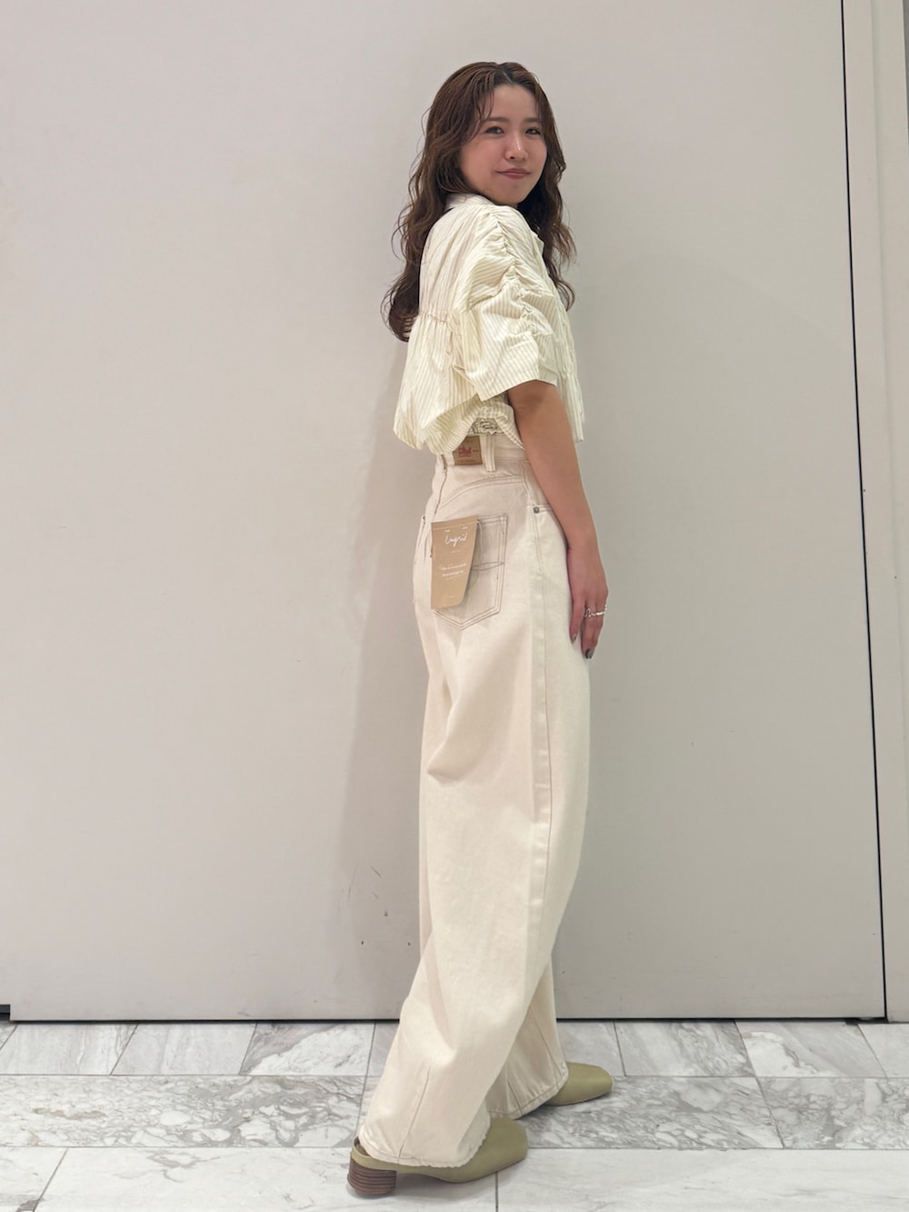 ホワイト系のデニムパンツ、イエロー系のシャツ/ブラウス、イエロー系のサンダルを着用したレディースの春コーディネートの3枚目の写真