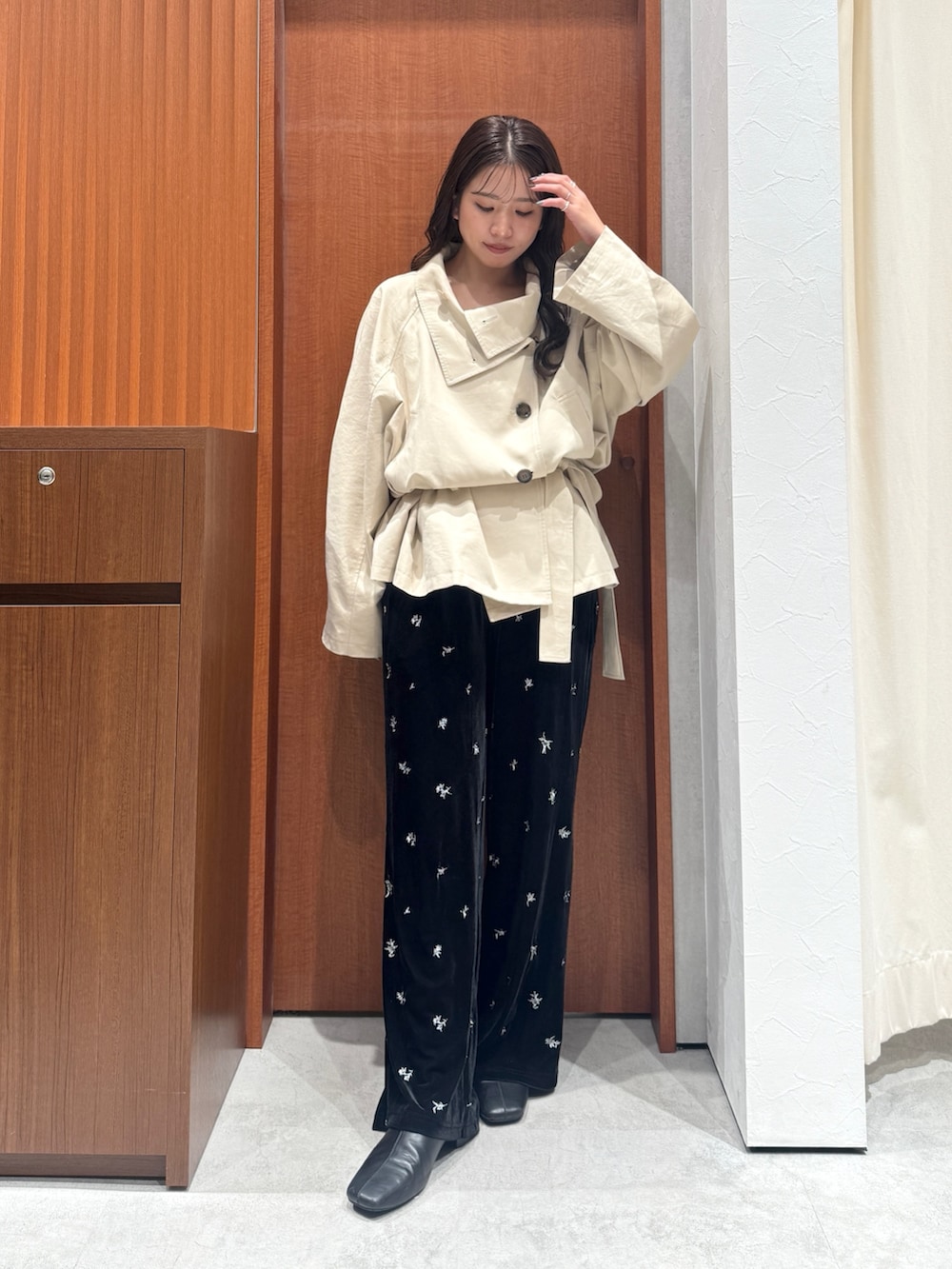ブラック系のその他パンツ、ベージュ系のトレンチコート、ブラック系のサンダルを着用したレディースの秋コーディネートの2枚目の写真
