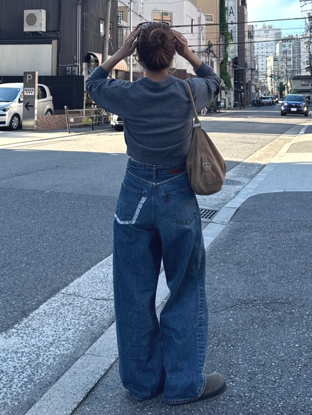 ベージュ系のスリッポン、グレー系のカーディガン/ボレロ、ブルー系のデニムパンツを着用したレディースの夏コーディネートの4枚目の写真