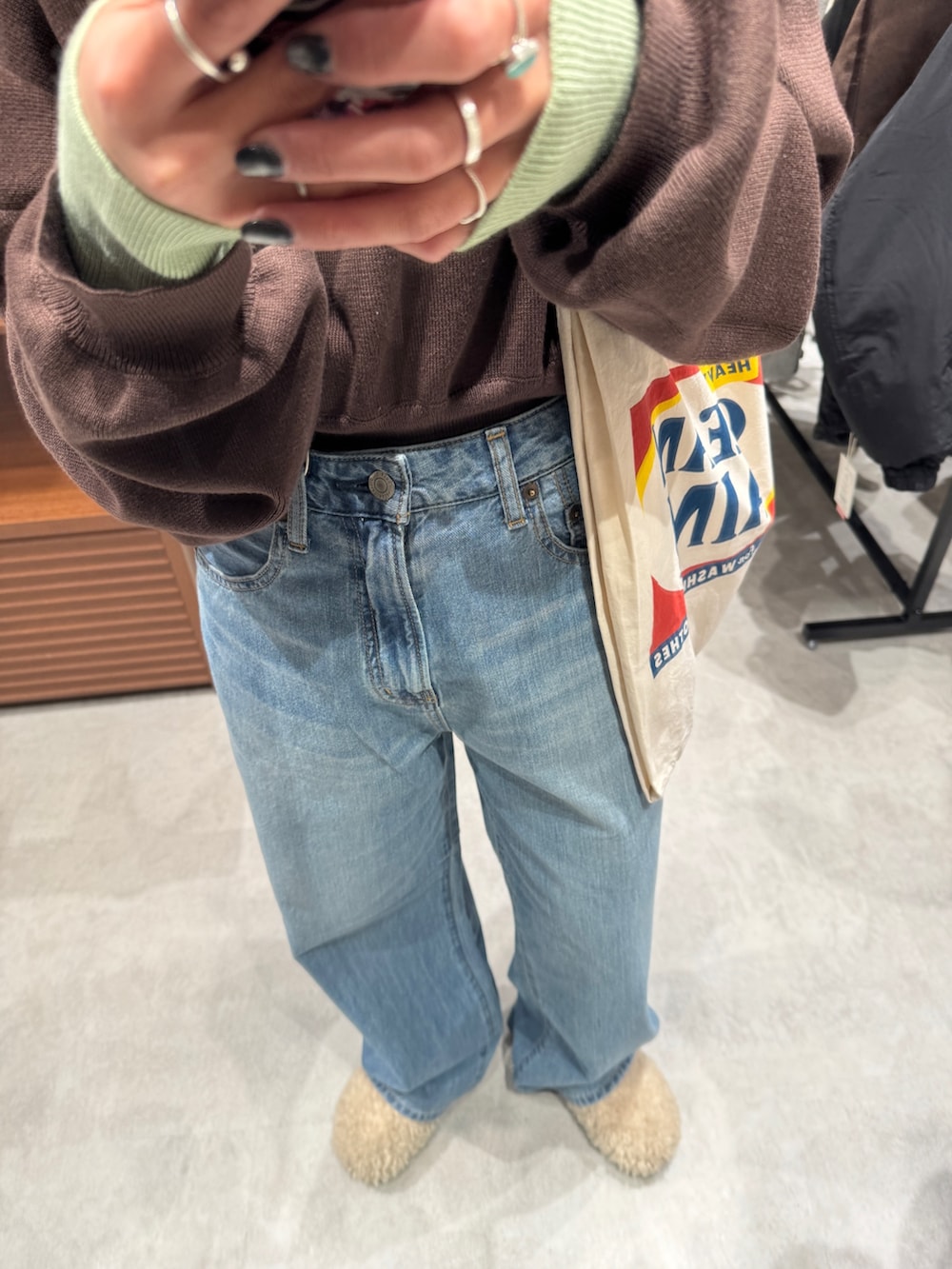 ブルー系のデニムパンツ、ブラウン系のニット/セーター、ホワイト系のトートバッグを着用したレディースの冬コーディネートの10枚目の写真