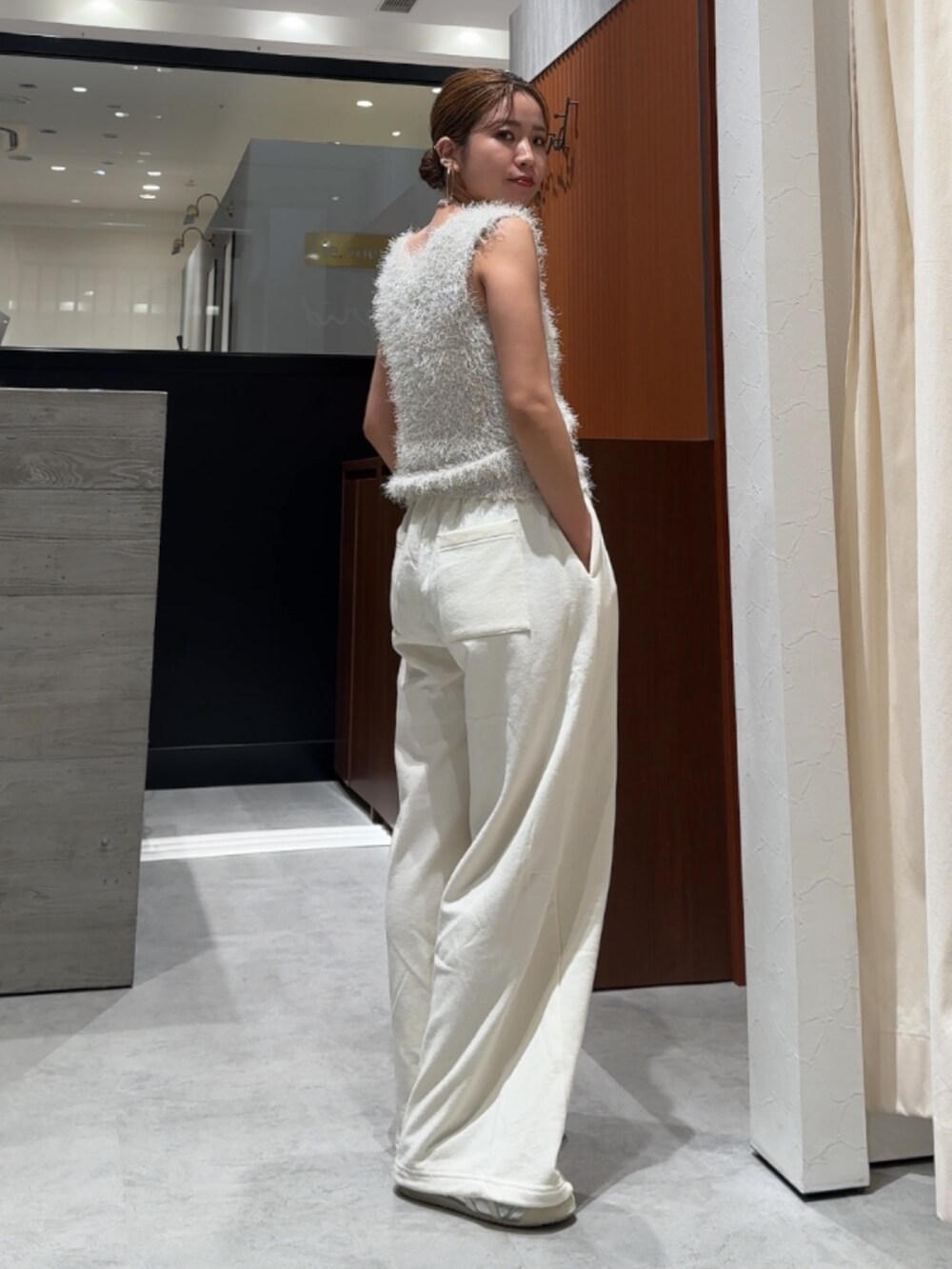 ホワイト系のスウェットパンツ、ホワイト系のベストを着用したレディースの春コーディネートの6枚目の写真