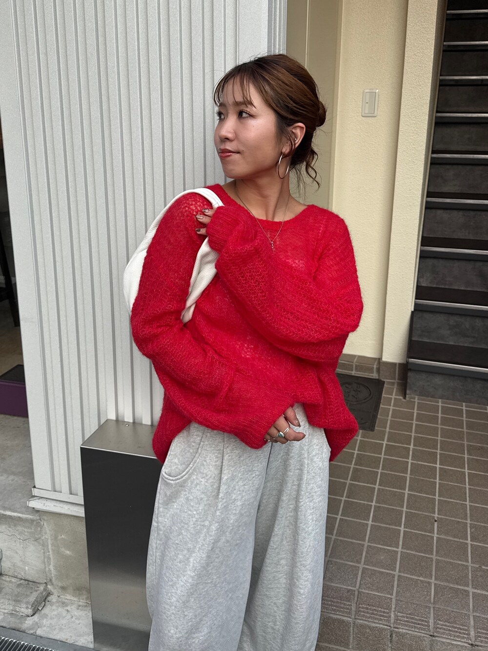 グレー系のスウェットパンツ、レッド系のニット/セーターを着用したレディースの秋コーディネートの9枚目の写真