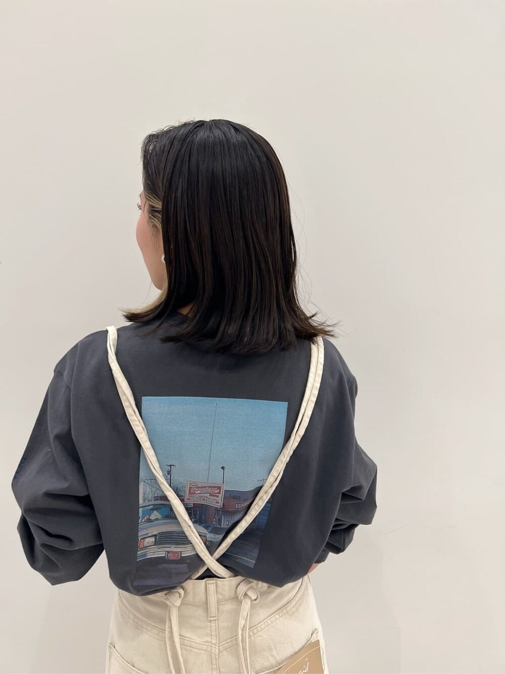 ホワイト系のデニムパンツ、グレー系のTシャツ/カットソーを着用したレディースの冬コーディネートの6枚目の写真