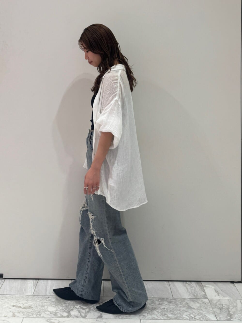 ブラック系のパンプス、ホワイト系のシャツ/ブラウス、ブルー系のデニムパンツを着用したレディースの春コーディネートの7枚目の写真