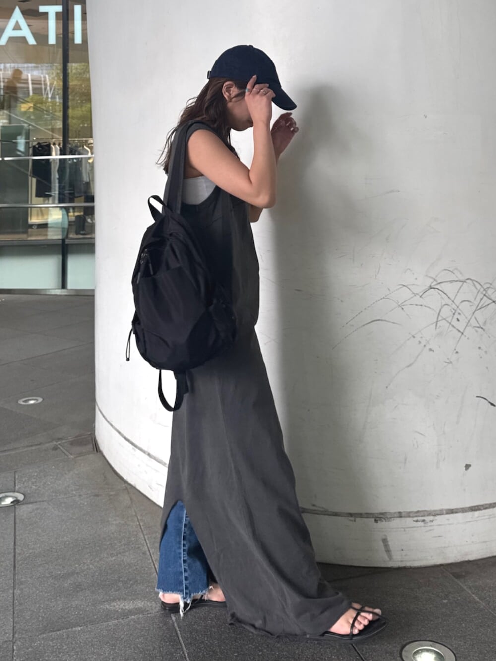 ブルー系のデニムパンツ、グレー系のワンピースを着用したレディースの春コーディネートの3枚目の写真