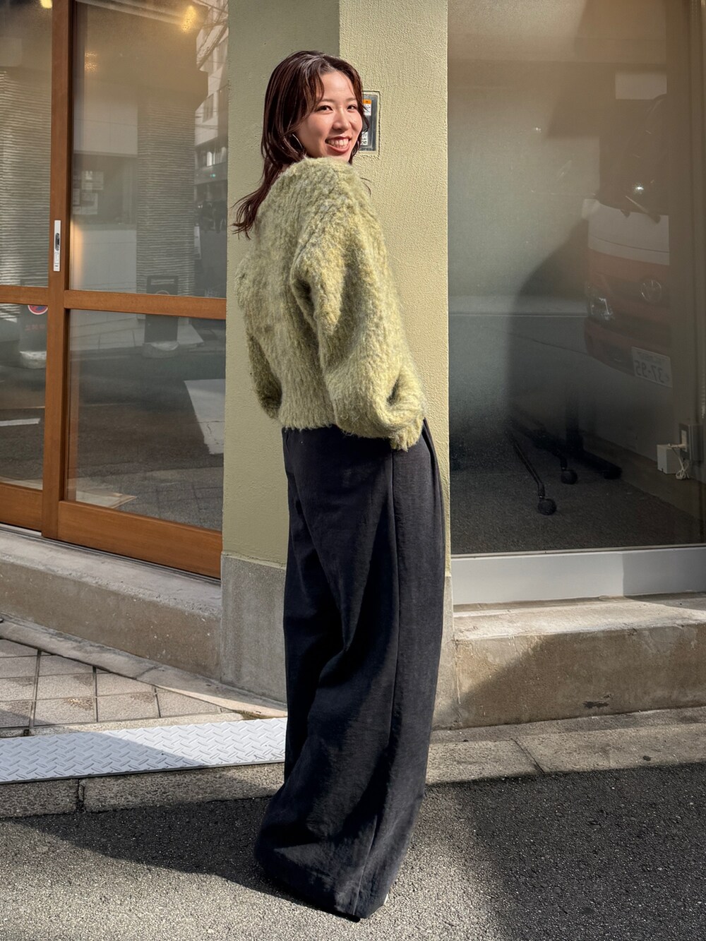 グレー系のその他パンツ、イエロー系のニット/セーターを着用したレディースの秋コーディネートの3枚目の写真